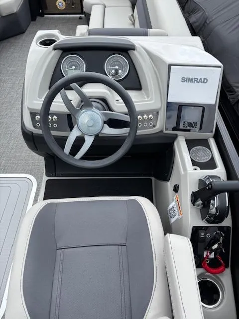 Slide: The Image of 2025 Barletta C24UC boat dashboard with steering wheel and Simrad display. - 2