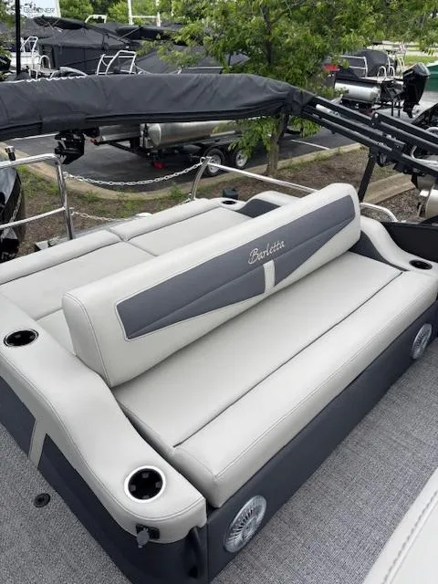 Slide: The Image of 2025 Barletta C24UC boat with luxurious seating and cup holders, docked outdoors. - 8
