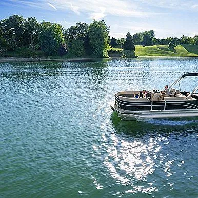 Slide: The Image of 2025 Harris Cruiser 210 FC pontoon boat on a serene lake with lush green surroundings. - 5