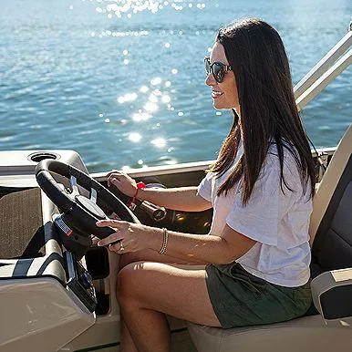 Slide: The Image of Woman steering 2025 Harris Cruiser 210 FC boat on sunny day. - 7