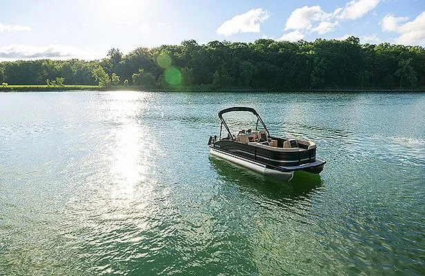 Slide: The Image of 2025 Harris Cruiser 210 CW pontoon boat on a serene lake under a sunny sky. - 6