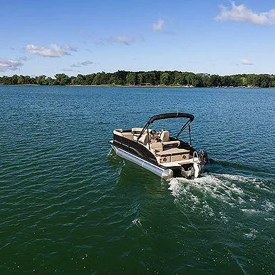 Slide: The Image of 2025 Harris Cruiser 210 CW pontoon boat cruising on a serene lake. - 8