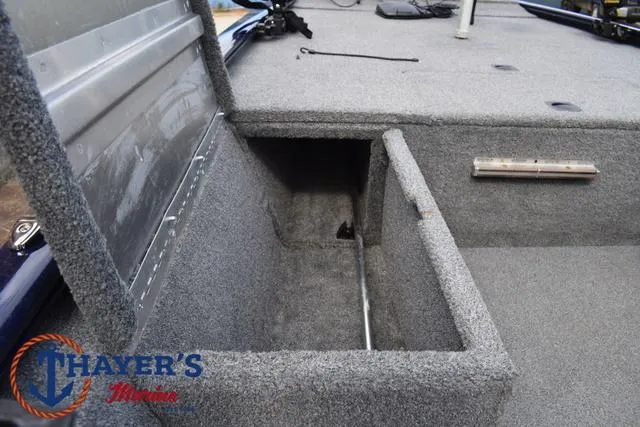 Slide: The Image of 2019 Tracker Pro 170 boat storage compartment with open lid, carpeted interior. - 14