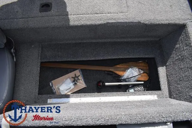 Slide: The Image of 2019 Tracker Pro 170 storage compartment with paddle and accessories, Thayer's Marine logo visible. - 19