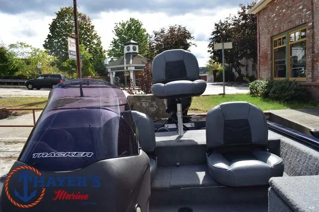 Slide: The Image of 2019 Tracker Pro 170 boat with seating, parked outdoors near a brick building. - 24