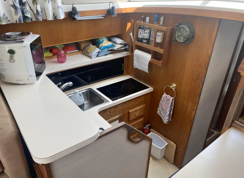 Slide: The Image of 1987 Silverton 34 Convertible boat kitchen with wooden cabinetry and modern appliances. - 11
