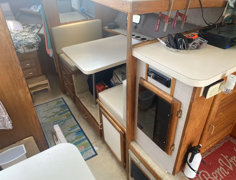 Slide: The Image of 1987 Silverton 34 Convertible interior with dining area, kitchenette, and cozy sleeping quarters. - 12