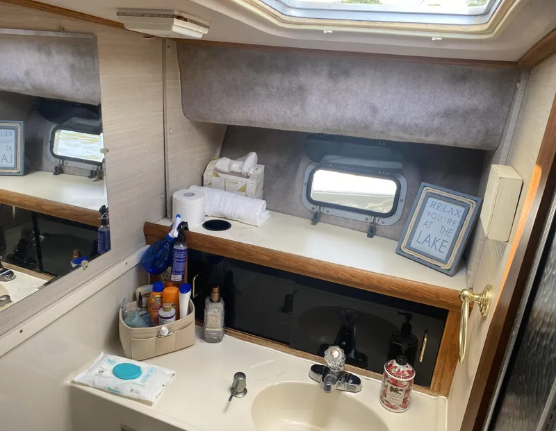 Slide: The Image of 1987 Silverton 34 Convertible bathroom with sink, toiletries, and window. - 14