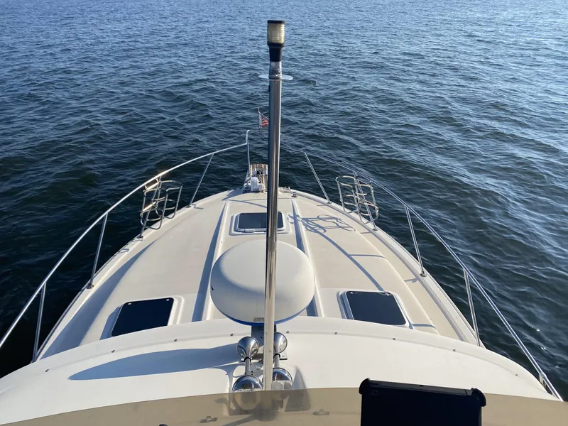 Slide: The Image of 1987 Silverton 34 Convertible boat on calm water, viewed from the bow. - 2
