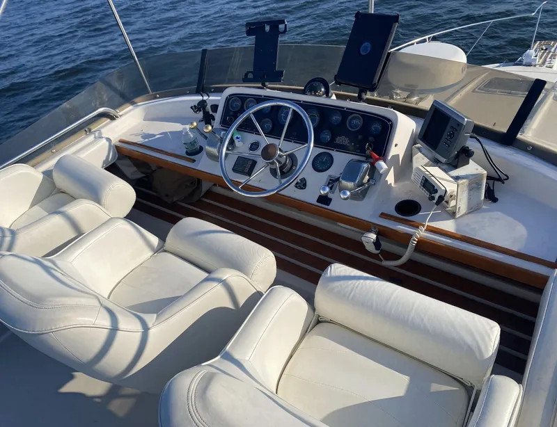 Slide: The Image of 1987 Silverton 34 Convertible boat cockpit with white leather seats and navigation instruments. - 5