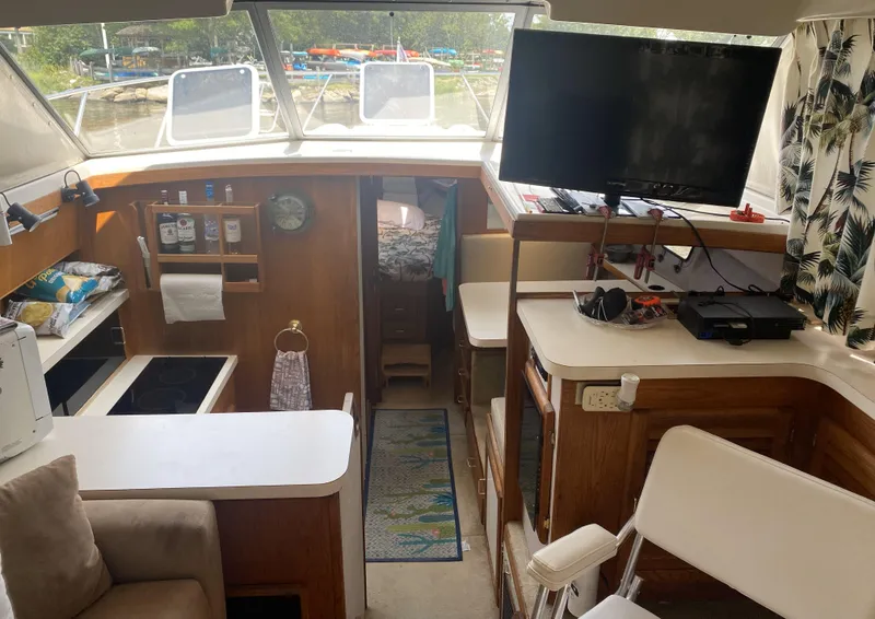 Slide: The Image of Interior of 1987 Silverton 34 Convertible boat with kitchen, seating, and TV. - 8