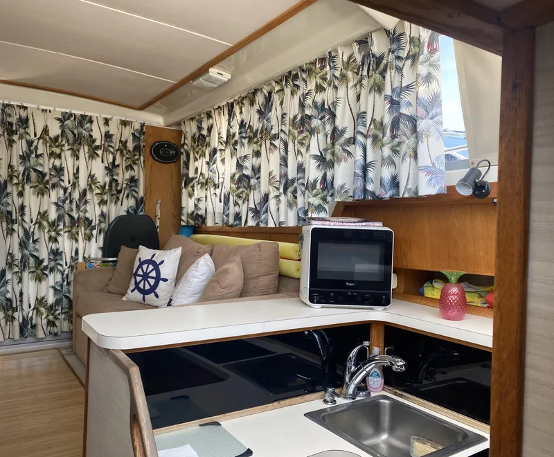 Slide: The Image of Interior of 1987 Silverton 34 Convertible with tropical curtains and cozy seating area. - 9