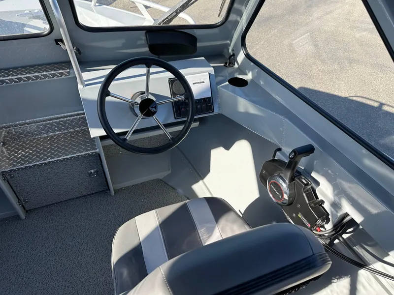 Slide: The Image of Interior of 2025 Hewescraft 200 ProV boat, featuring steering wheel and control panel. - 7