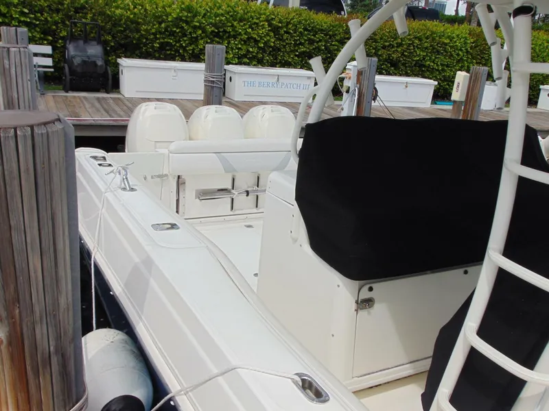 Slide: The Image of 2013 Boston Whaler 370 Outrage docked, featuring sleek design and spacious seating. - 12