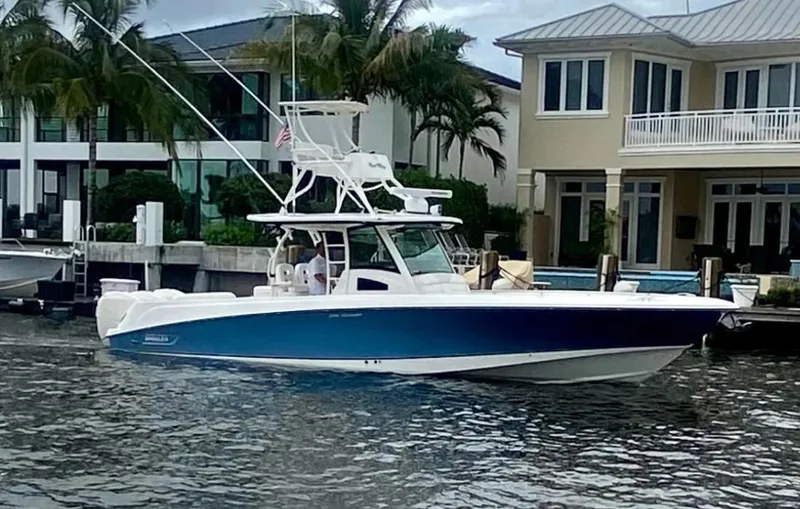 Slide: The Image of 2013 Boston Whaler 370 Outrage boat docked near waterfront homes. - 2