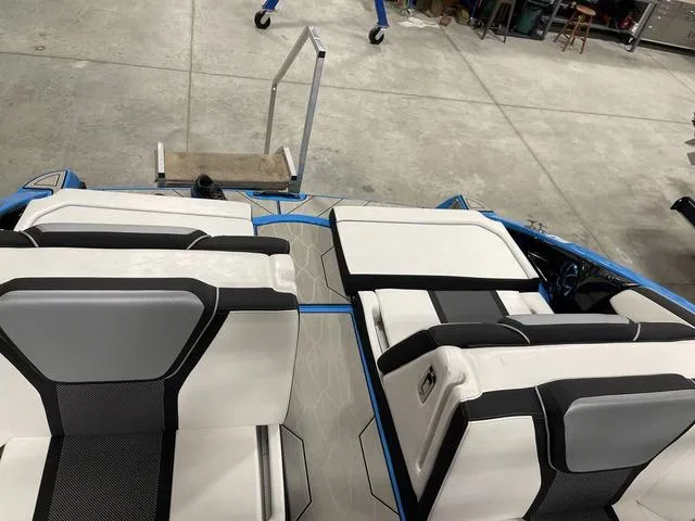 Slide: The Image of 2023 Yamaha Boats 255XD interior with white and black seating in a showroom. - 10