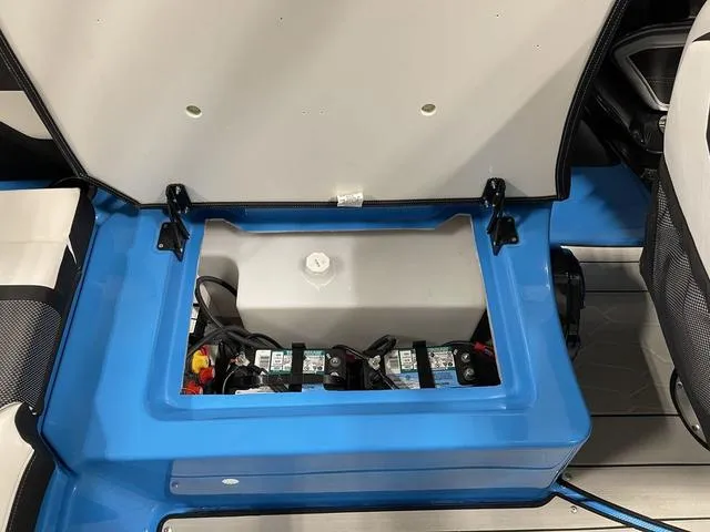 Slide: The Image of 2023 Yamaha Boats 255XD battery compartment with blue interior detailing. - 12