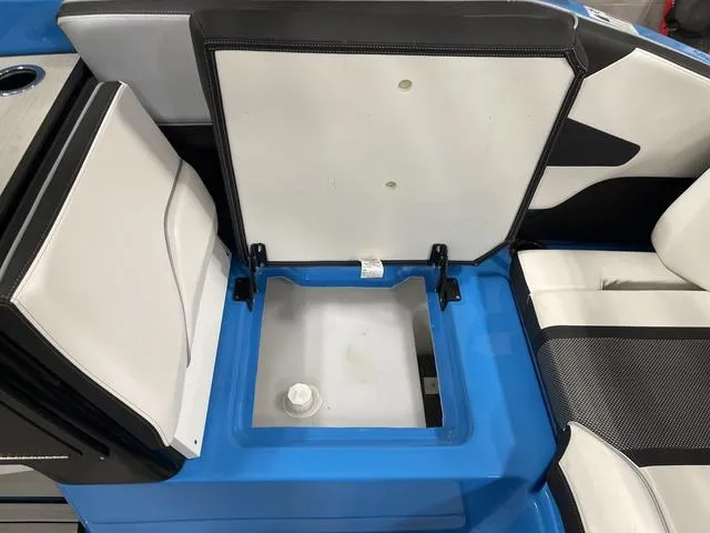 Slide: The Image of 2023 Yamaha Boats 255XD interior storage compartment with open seat, showcasing blue and white design. - 14