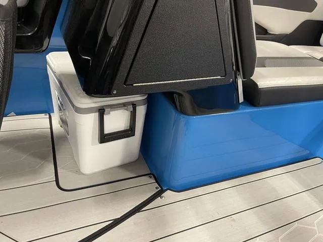 Slide: The Image of 2023 Yamaha Boats 255XD interior with blue accents and storage compartment. - 19