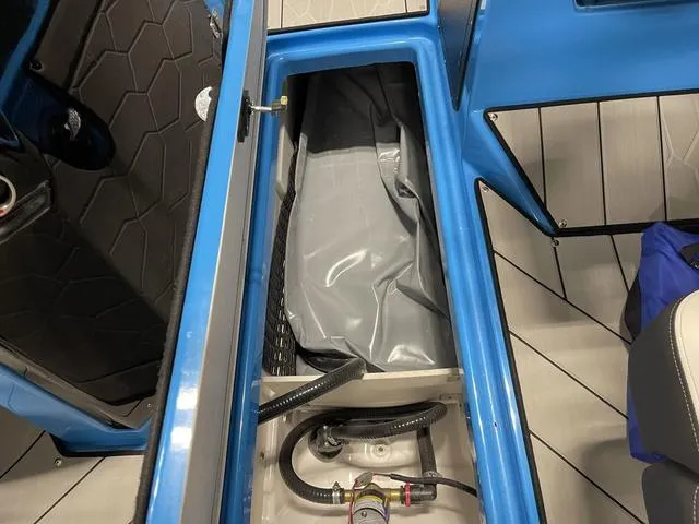 Slide: The Image of 2023 Yamaha Boats 255XD interior storage compartment with blue and gray design. - 20