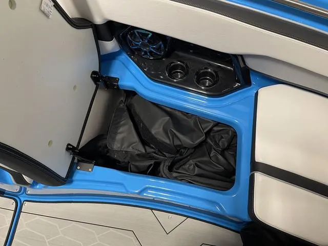 Slide: The Image of 2023 Yamaha Boats 255XD storage compartment with cup holders and speaker. - 28