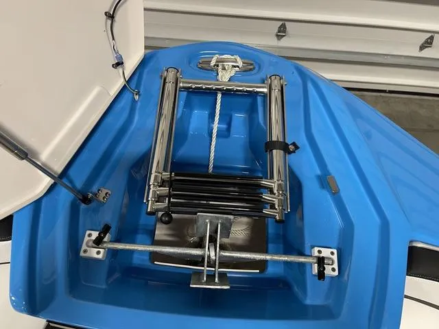 Slide: The Image of 2023 Yamaha Boats 255XD anchor compartment with stainless steel hardware and blue interior. - 31