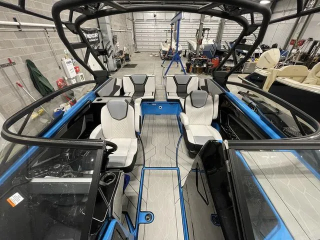 Slide: The Image of 2023 Yamaha Boats 255XD interior with modern seating and sleek design in a showroom. - 35