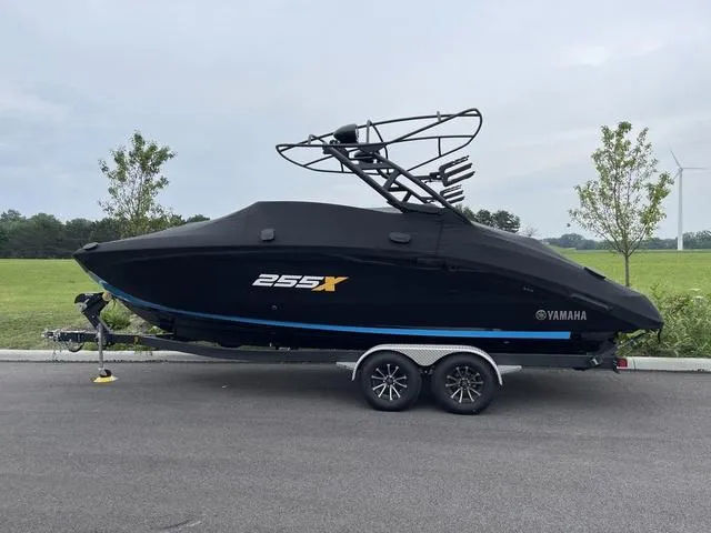 Slide: The Image of 2023 Yamaha Boats 255XD, black cover, on trailer, parked outdoors. - 4