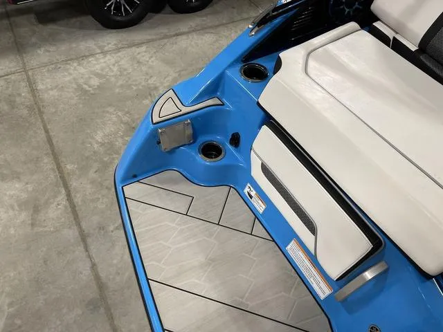 Slide: The Image of 2023 Yamaha Boats 255XD interior, featuring blue and white seating with cup holders. - 45