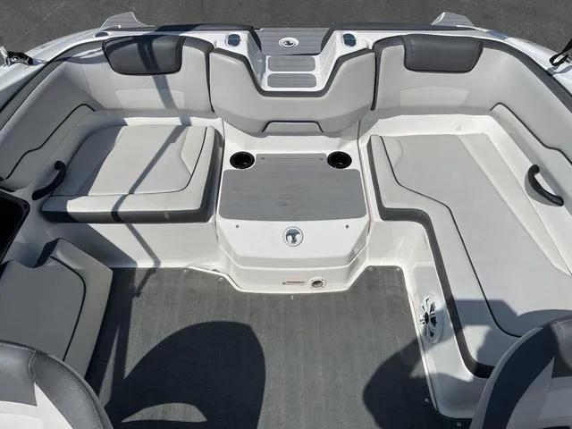 Slide: The Image of 2019 Yamaha Boats SX190 interior seating area with gray upholstery and cup holders. - 17