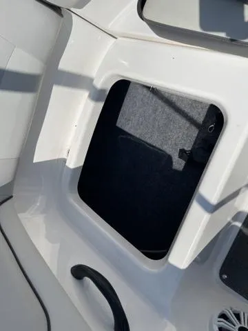 Slide: The Image of 2019 Yamaha Boats SX190 storage compartment with open hatch, showcasing interior space. - 19
