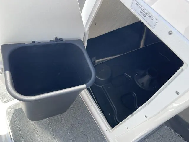 Slide: The Image of 2019 Yamaha SX190 boat storage compartment with trash bin and fire extinguisher holder. - 25
