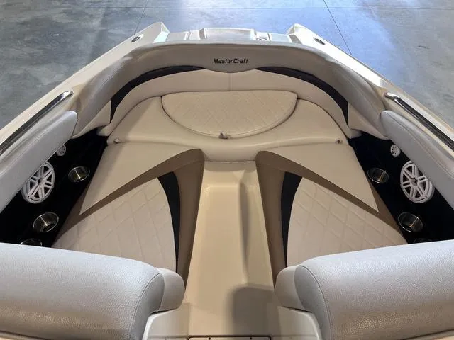 Slide: The Image of 2010 MasterCraft X-Star boat interior with beige and black seating, cup holders, and speakers. - 25