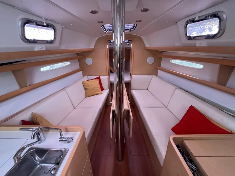Slide: The Image of Interior of 2012 Beneteau First 30 sailboat with modern seating and kitchen area. - 9