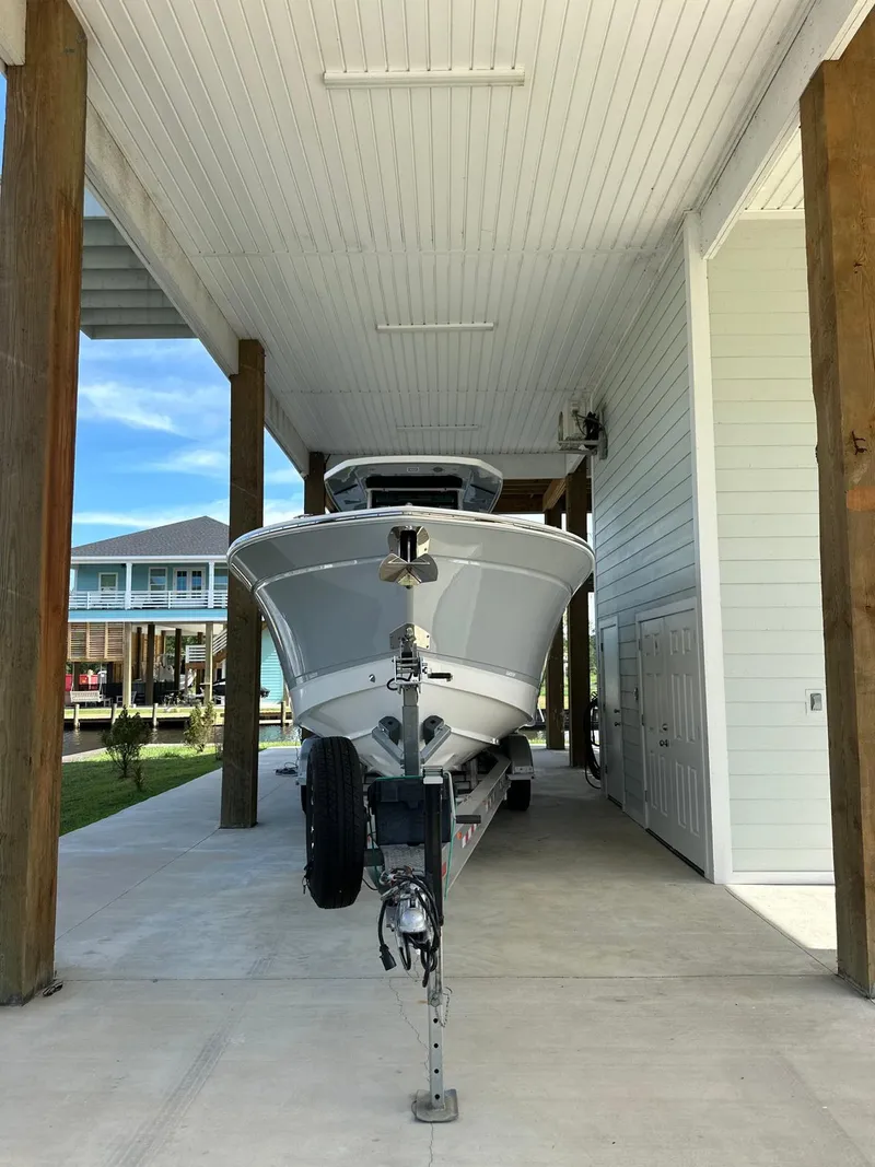 Slide: The Image of 2023 Blackfin 302CC boat parked under a covered dock. - 14