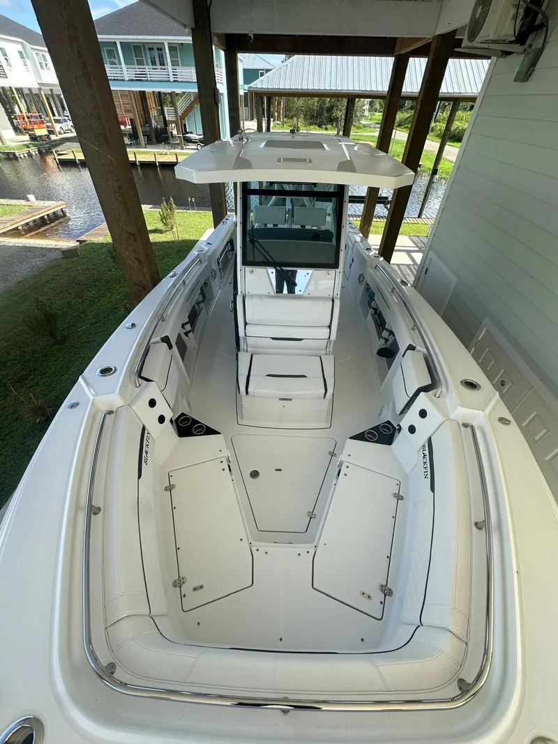 Slide: The Image of 2023 Blackfin 302CC boat docked, showcasing spacious deck and modern design. - 4