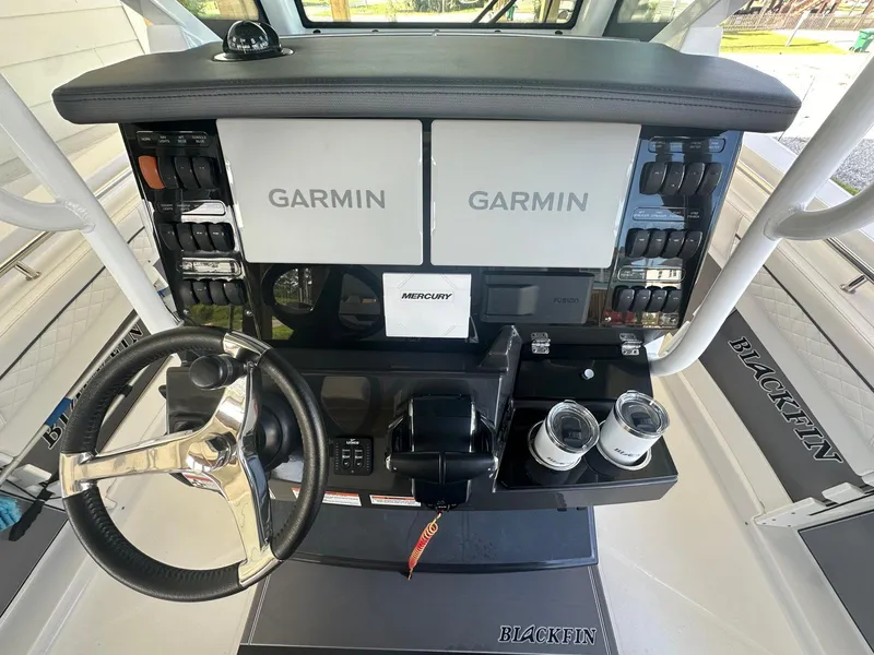 Slide: The Image of 2023 Blackfin 302CC helm with dual Garmin displays and Mercury controls. - 5