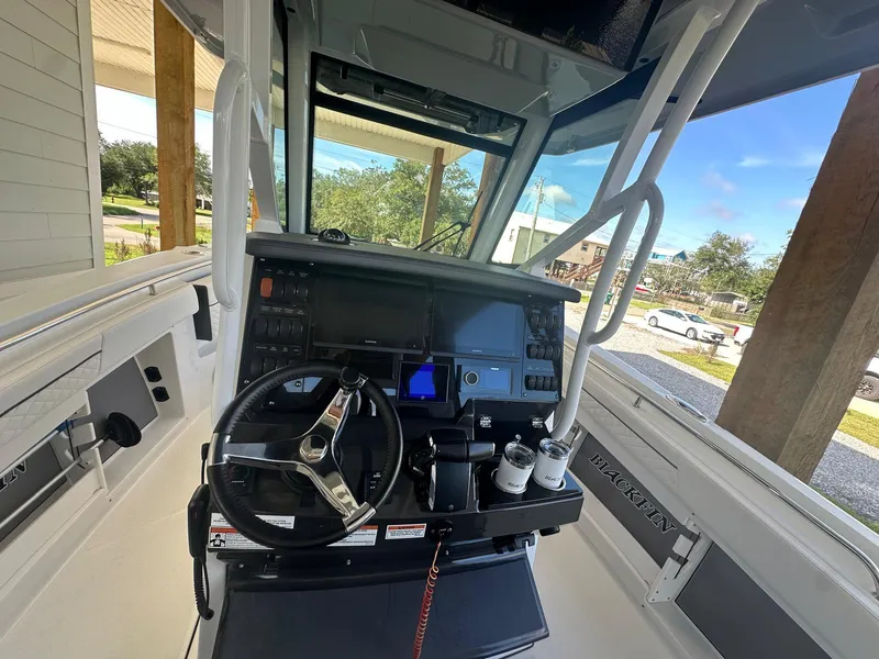 Slide: The Image of 2023 Blackfin 302CC boat cockpit with modern steering and navigation controls. - 6