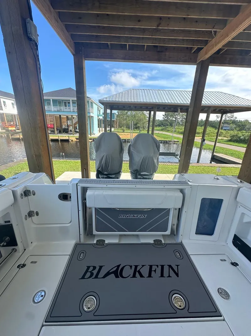 Slide: The Image of 2023 Blackfin 302CC boat interior under a wooden dock, showcasing seating and storage. - 7
