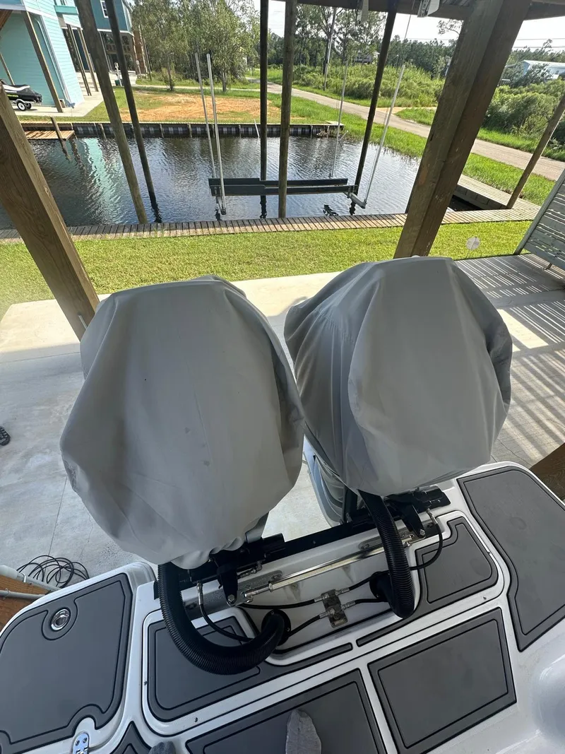 Slide: The Image of 2023 Blackfin 302CC boat engines covered, docked near a serene waterfront. - 8