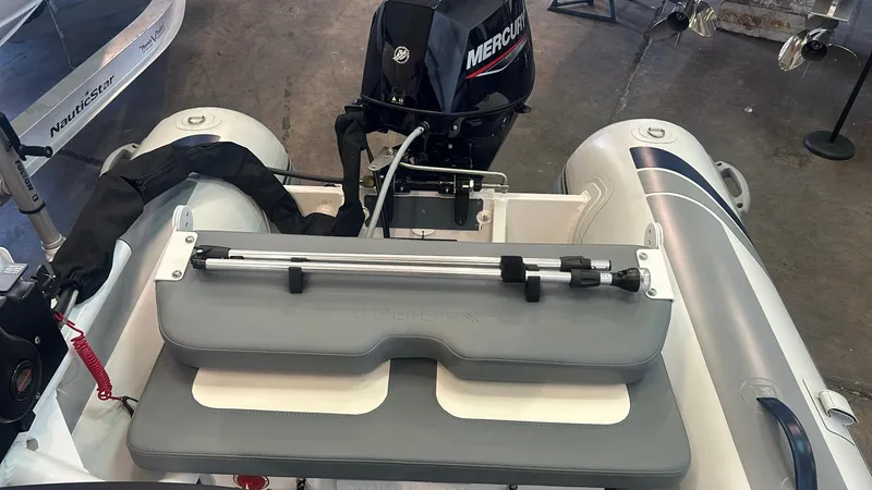 Slide: The Image of 2025 Highfield CL380 inflatable boat with Mercury outboard motor, featuring a gray seat and steering mechanism. - 2