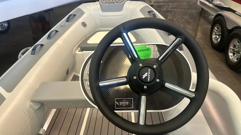 Slide: The Image of 2025 Highfield CL380 boat steering wheel with carbon fiber accents and modern design. - 6