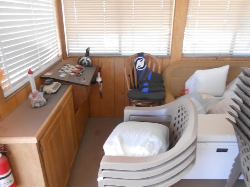 Slide: The Image of 1986 Hanson houseboat interior with control panel, chairs, and life jacket. - 10