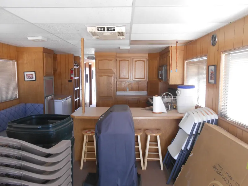 Slide: The Image of Interior of a 1986 Hanson houseboat with wooden paneling and kitchen area. - 12