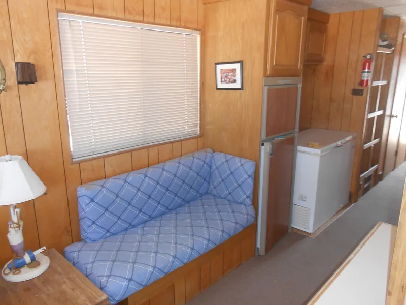Slide: The Image of Interior of a 1986 Hanson houseboat with wood paneling and blue plaid seating. - 15