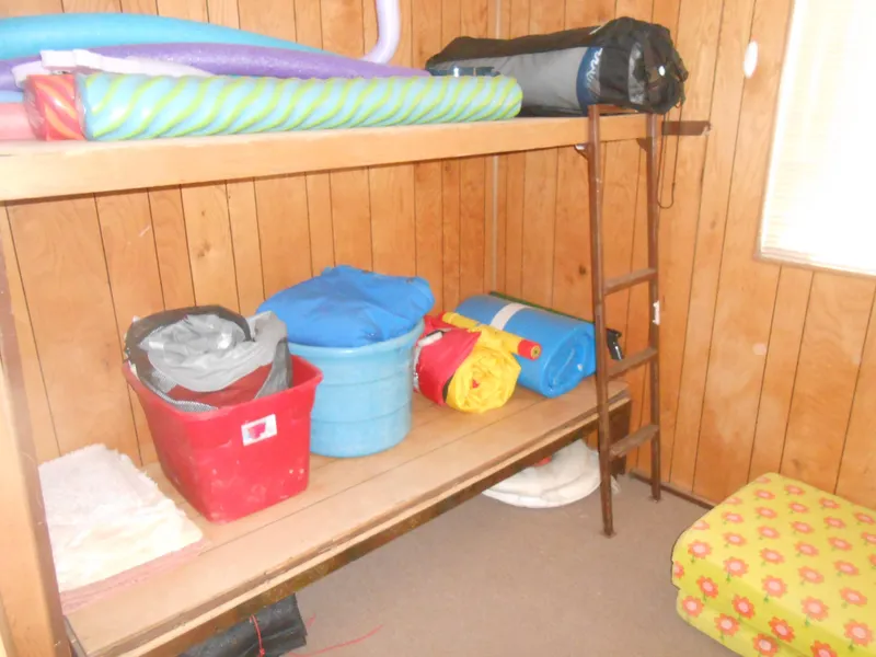 Slide: The Image of Storage area in 1986 Hanson houseboat with shelves, bins, and rolled mats. - 21