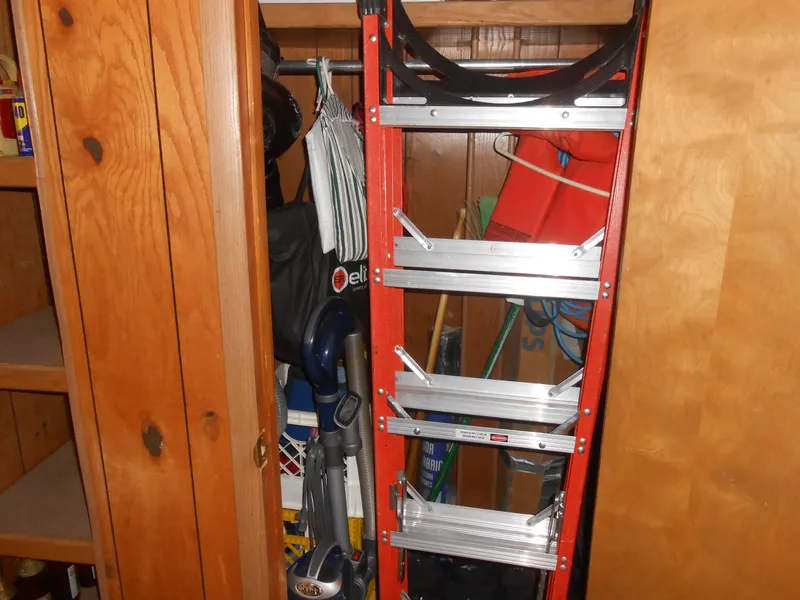 Slide: The Image of Red ladder stored in a wooden cabinet on a 1986 Hanson houseboat. - 22