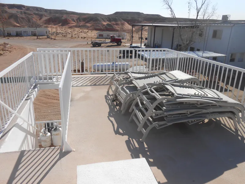 Slide: The Image of Rooftop deck of 1986 Hanson houseboat with stacked lounge chairs and scenic desert view. - 27