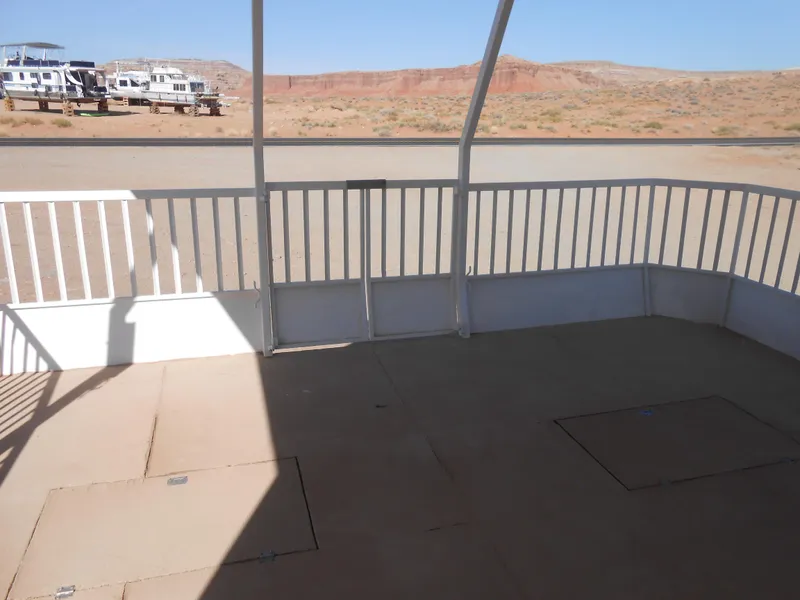 Slide: The Image of 1986 Hanson houseboat deck with railing, overlooking desert landscape and distant houseboats. - 5
