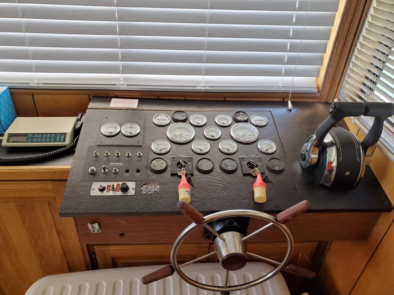 Slide: The Image of Control panel of a 1986 Hanson houseboat with gauges, steering wheel, and throttle. - 7